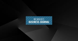 Milwaukee Business Journal logo on dark, abstract background