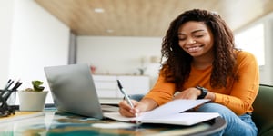 Woman working remote smiling at laptop