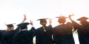 Group of graduates facing backwards holding diplomas