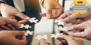 Staff holding puzzle pieces with award logo for 