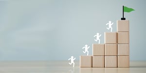 Outline of a person running up blocks to get to a green flag at the top