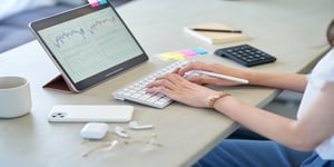 Hands typing on keyboard at desk