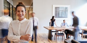 Woman standing proudly at work with arms crossed