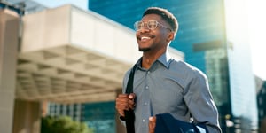 Happy professional man walking and smiling in a city