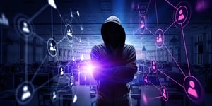 Figure of a hooded man layered on cybersecurity background.