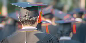The back of a graduates head in crowd of peers