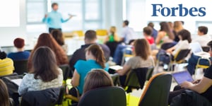 Blurred classroom with FORBES logo in top right corner