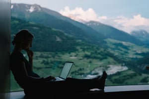 Woman working outside on computer with sunrise