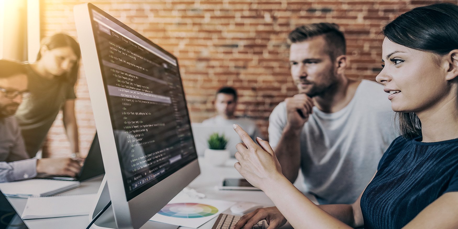Man and woman software developers at work looking at code on computer