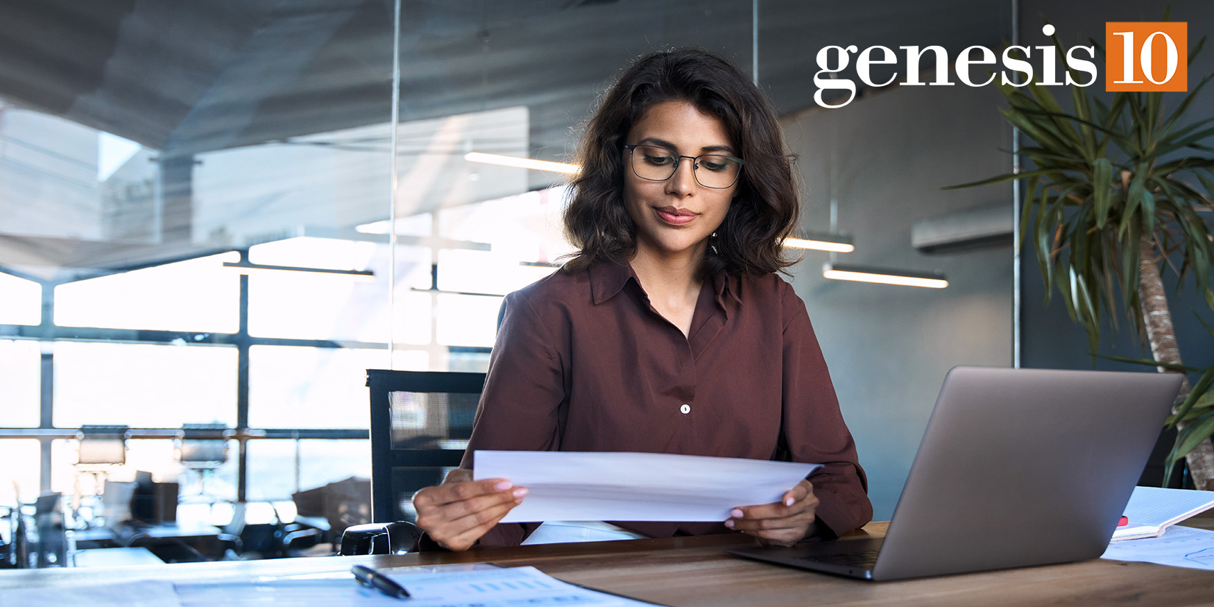 Businesswoman smiling at work-genesis10 logo in top right corner