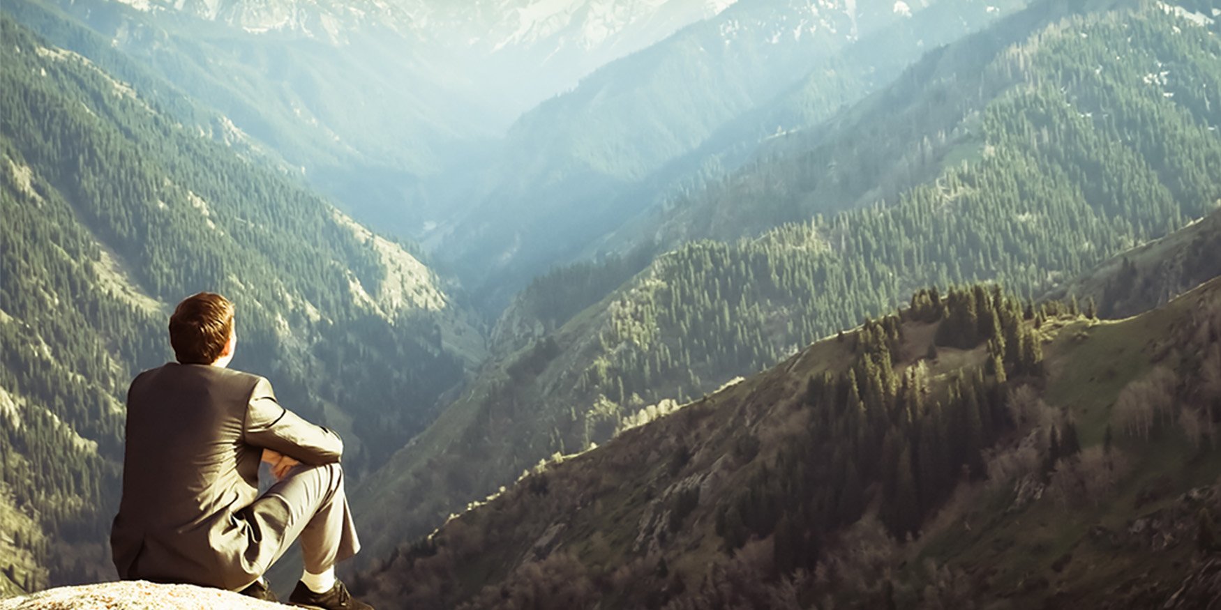 Man in suit overlooking mountain view