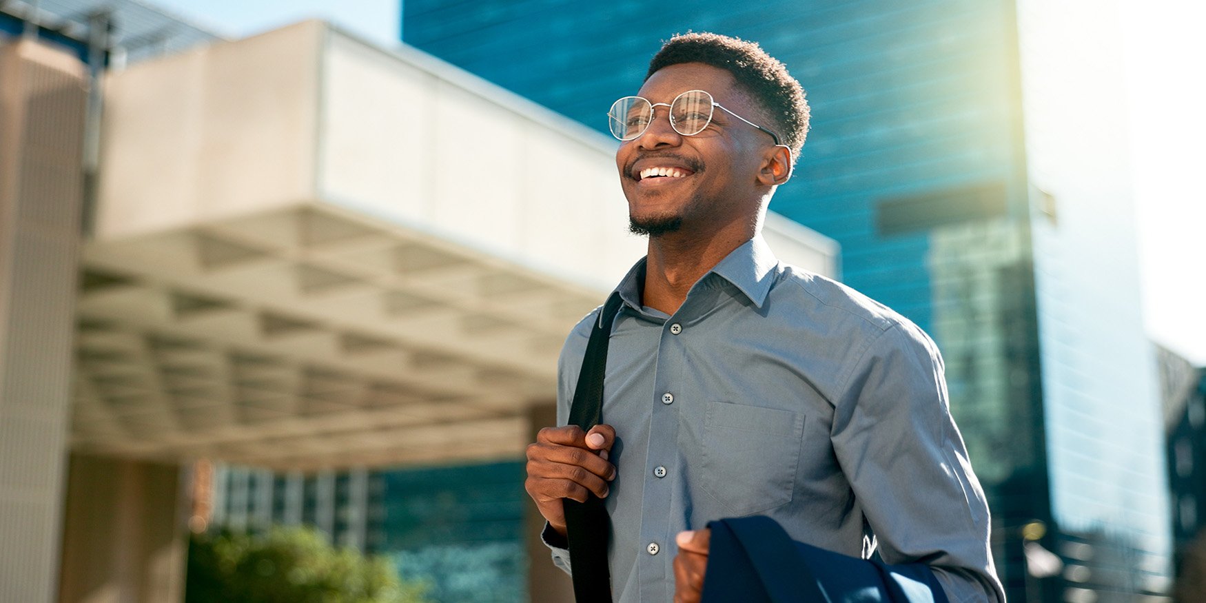 Happy professional man walking and smiling in a city