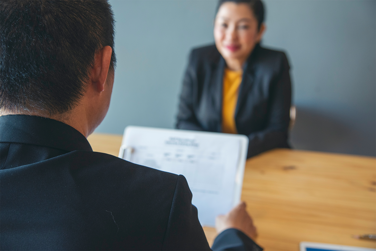 Man facing towards woman smiling during interview