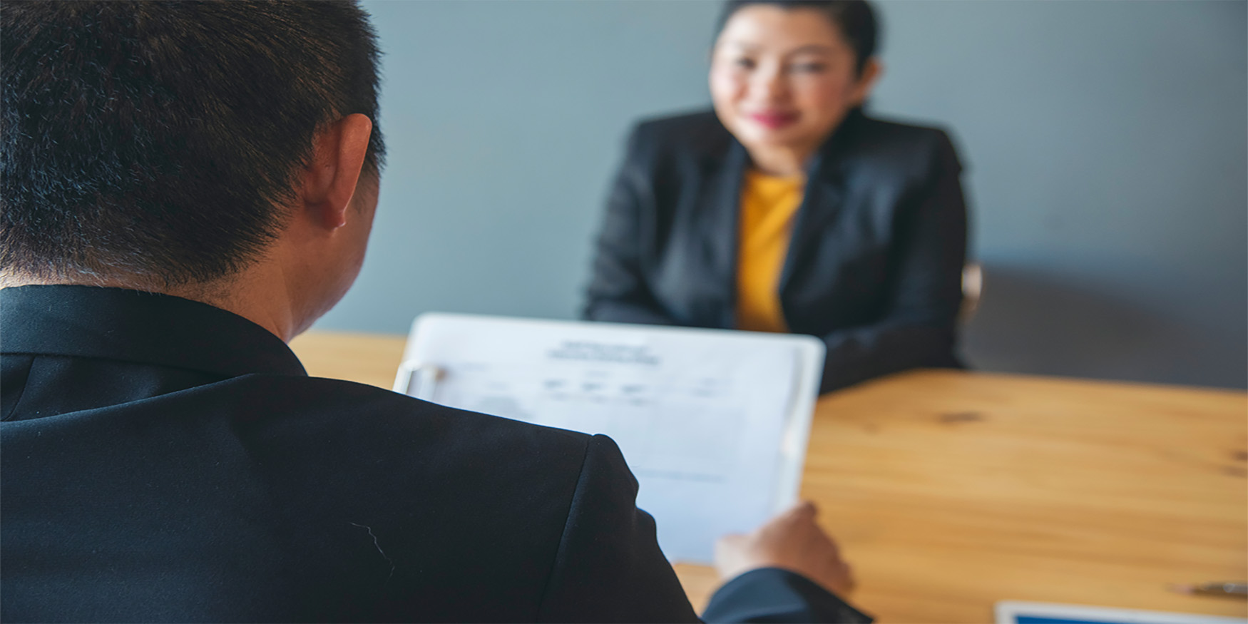 Man facing towards woman smiling during interview
