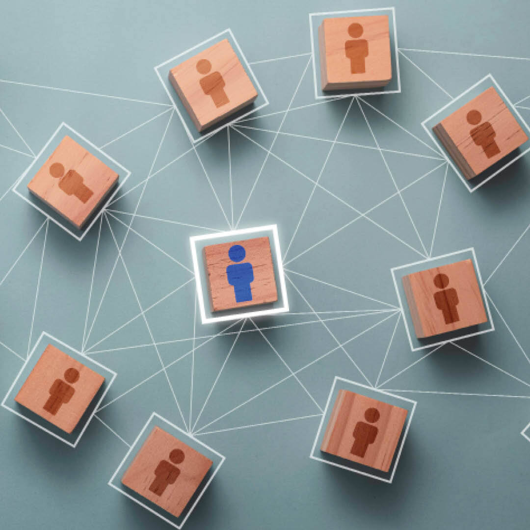 Blocks with red silhouettes of people surrounding one highlighted block with a blue silhouette of a person, connected by a web 