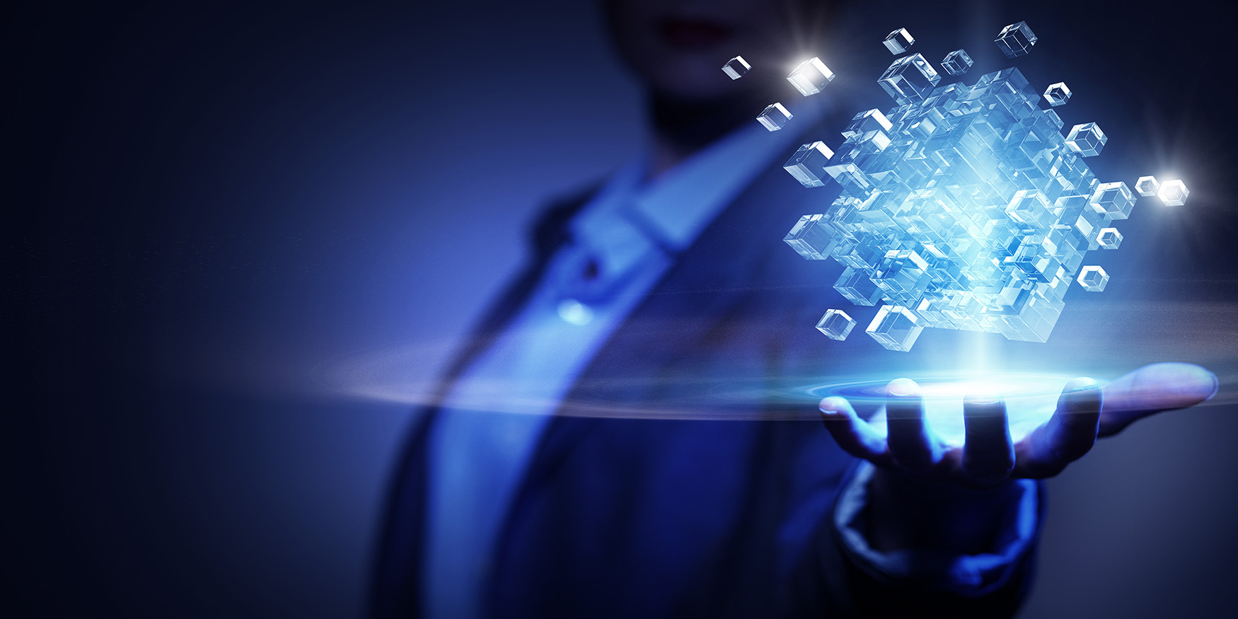 Man suit holding hand out palm up, above his hand are blue floating cubes