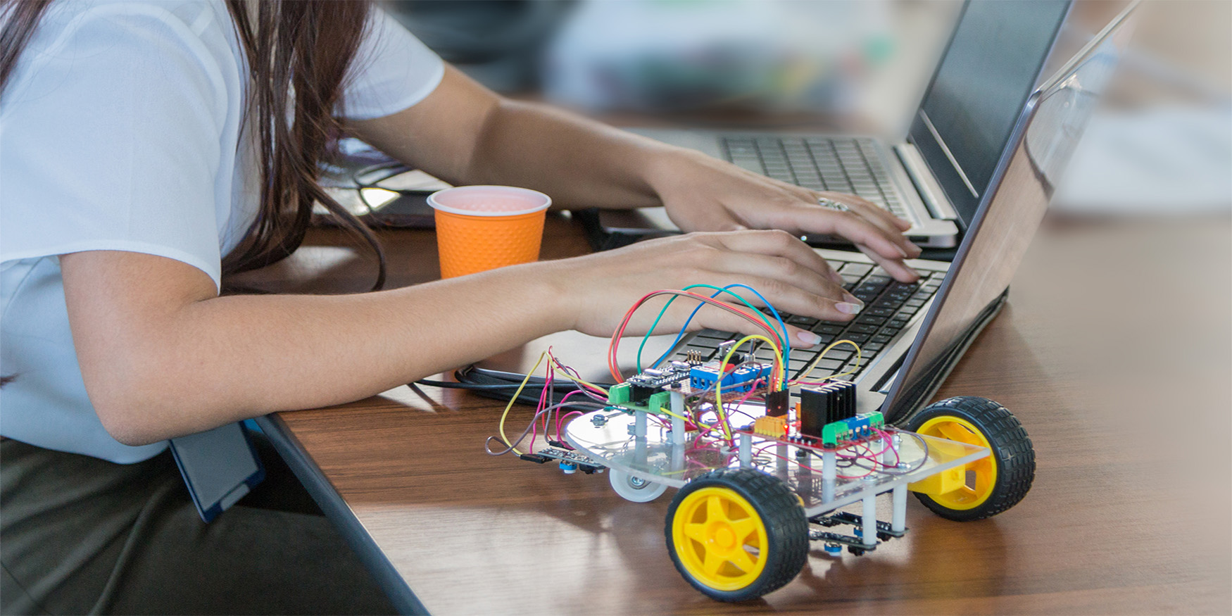 Students code a metal car robot and an electronic board