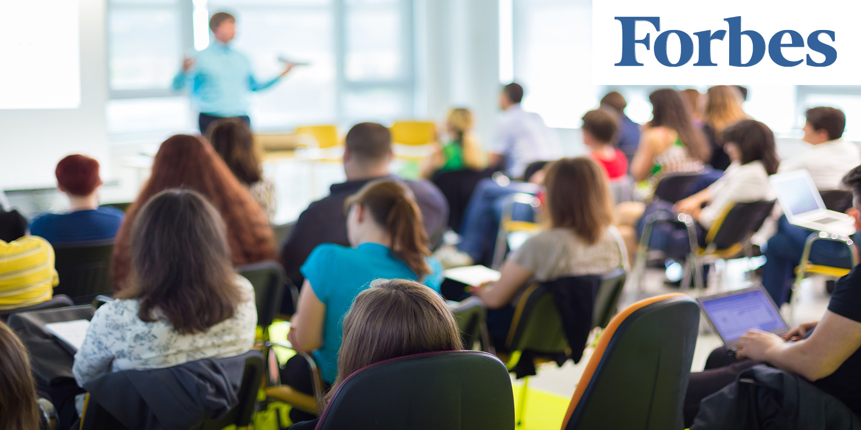 Blurred classroom with FORBES logo in top right corner